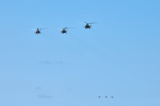 Military helicopters flying in blue sky performing demonstration flight, aerobatic team, air show photo