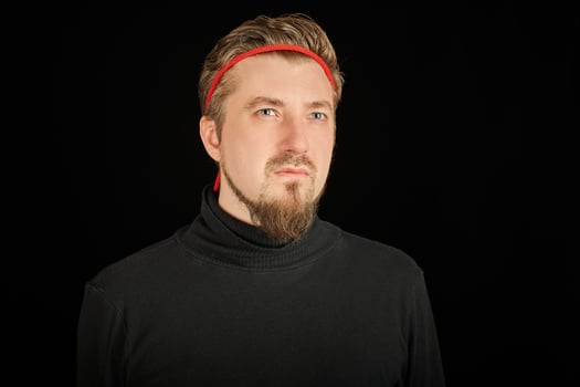 Funny bearded man with red headband, black background photo
