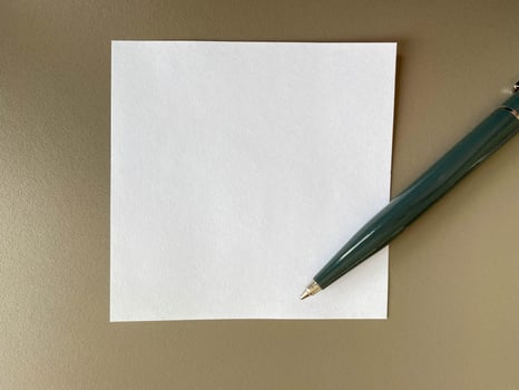 Small square pieces of paper for notes and notes on the office desk and a green ballpoint pen. Business work photo