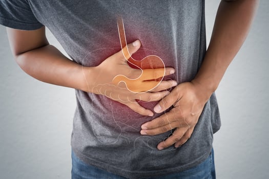 Acid reflux or Heartburn, The photo of stomach is on the men's body against gray Background, Bad health, Male anatomy concept