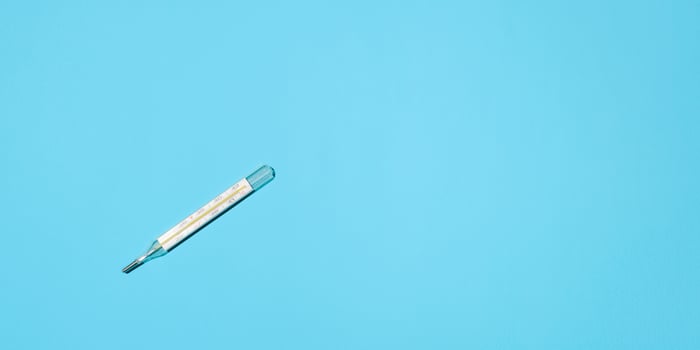 Celsius thermometer lying on a blue background, flat lay. Banner, place for text photo