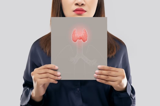 illustration of the thyroid in the gray paper is on the woman's neck. Female thyroid gland control. Sore throat of a people against a light gray background photo