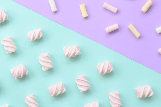 Colorful marshmallow laid out on violet and blue paper background. pastel creative textured pattern. minimal photo