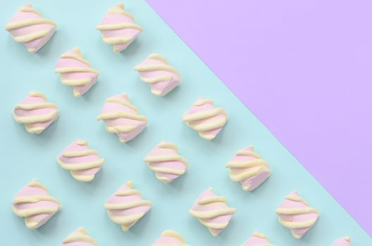 Colorful marshmallow laid out on violet and blue paper background. pastel creative textured pattern. minimal photo