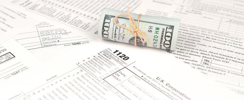 1120 U.S. Corporation income tax return form with roll of american dollar banknotes photo