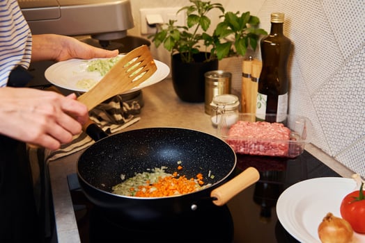 Woman cooking sauce bolognese in kitchen photo
