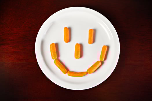 Carrot smile on white plate photo