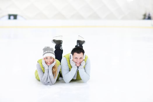Cheerful couple lying on the skating rink photo