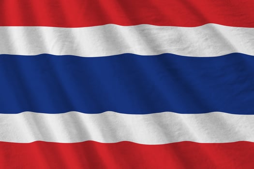 Thailand flag with big folds waving close up under the studio light indoors. The official symbols and colors in banner photo