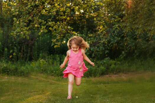 happy baby smiling. little girl running at a sunset outdoor photo