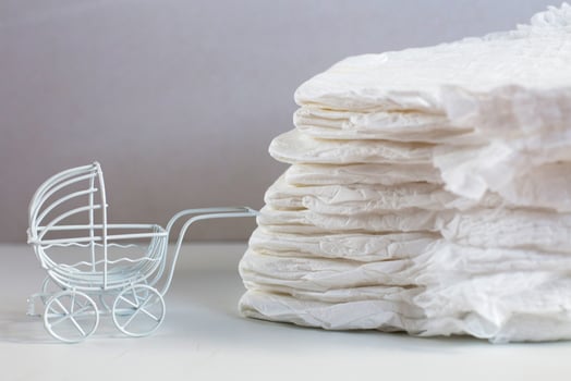 Baby diapers with toy carriage on a white background photo