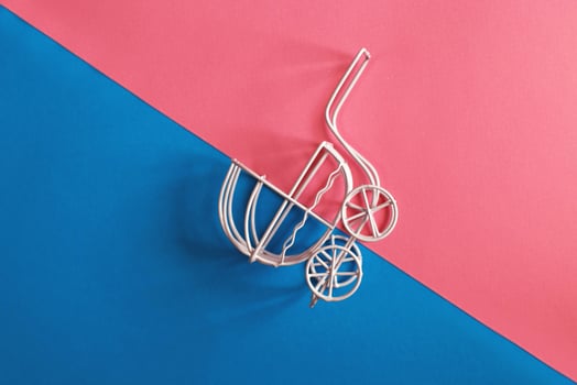 vintage baby stroller on pink and blue background. Boy or girl question photo