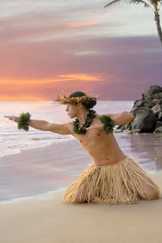 Male Hula Dancer on the beach with a sunset sky in the background photo
