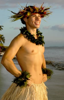 A smiling male hula dancer poses on beach at sunset. photo