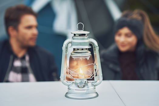 Young nice couple having fun on camping with kerosene lamp photo