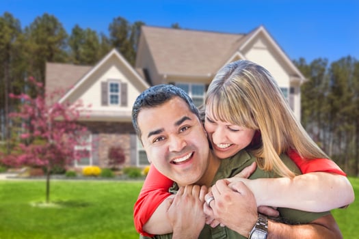 Mixed Race Couple Hugging in Front of House photo