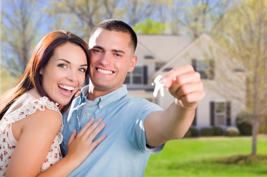 Military Couple with House Keys In Front of New Home photo