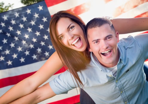 Military Couple Piggy Riding In Front of American Flag photo