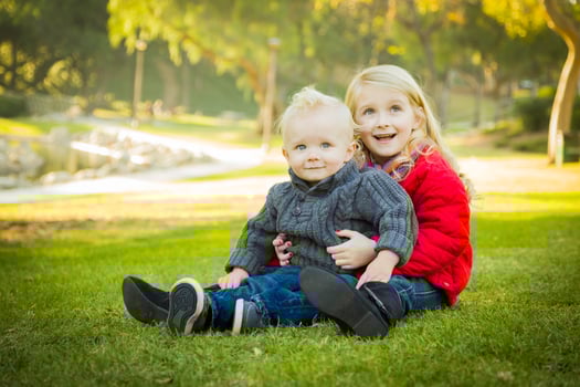 Little Girl with Baby Brother Wearing Coats at the Park photo