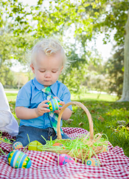 Cute Little Boy Enjoying His Easter Eggs Outside in Park photo