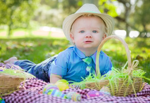Cute Little Boy Smiles With Easter Eggs Around Him photo