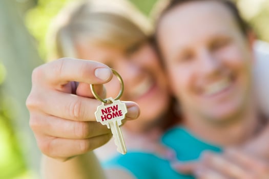 Couple Holding House Key with New Home Text photo