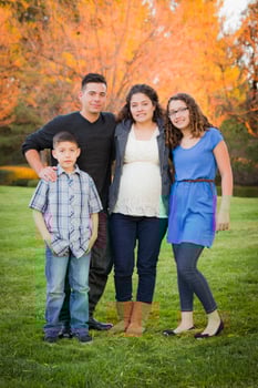 Attractive Hispanic Family Portrait in a Colorful Fall Outdoor Setting photo