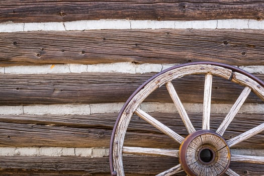 Abstract of Vintage Antique Log Cabin Wall and Wagon Wheel. photo