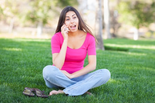 Beautiful Young Ethnic Woman Talking on Her Smartphone Outside. photo