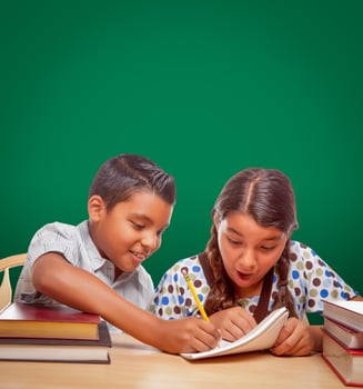 Blank Chalk Board Behind Hispanic Boy and Girl Having Fun Studying Together photo