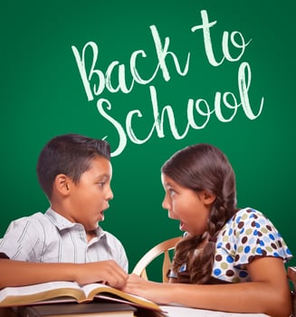 Back To School Written On Chalk Board Behind Hispanic Boy and Girl Having Fun Studying Together photo