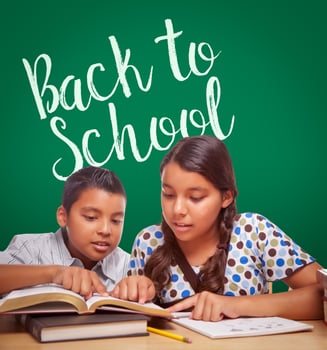 Back To School Written On Chalk Board Behind Hispanic Boy and Girl Having Fun Studying Together photo
