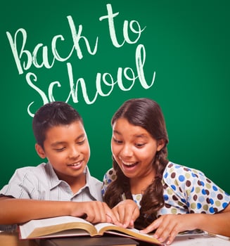Back To School Written On Chalk Board Behind Hispanic Boy and Girl Having Fun Studying Together photo