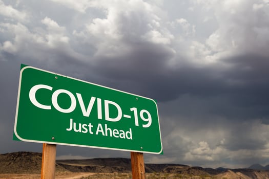 COVID-19 Coronavirus Green Road Sign Against Ominous Stormy Cloudy Sky photo