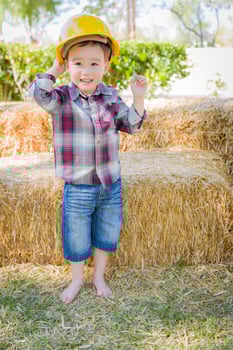 Young Mixed Race Boy Laughing with Hard Hat Outside photo