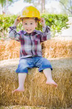 Young Mixed Race Boy Laughing with Hard Hat Outside photo