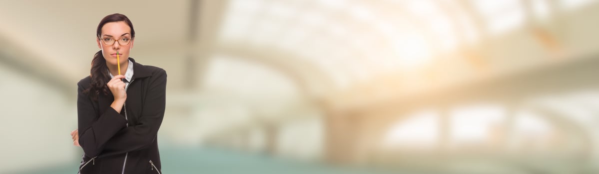 Serious Mixed Race Businesswoman With Pencil Inside Building Banner photo