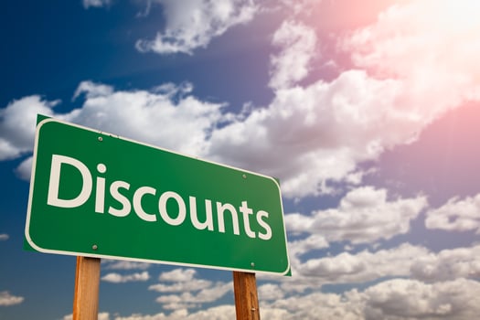 Discounts Green Road Sign Against Sky photo