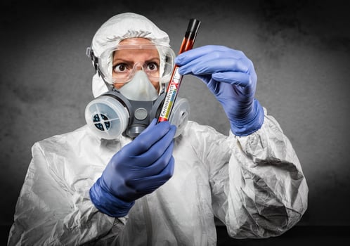 Female Doctor or Nurse In Hazmat Gear Holding Positive Coronavirus Test Tube photo
