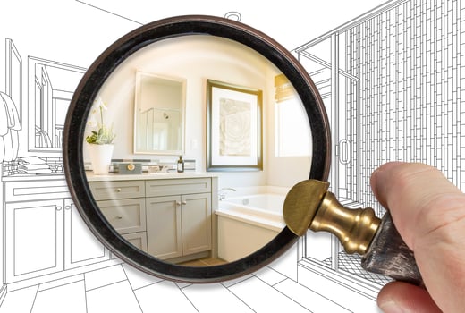 Hand Holding Magnifying Glass Revealing Finished Bathroom Build Over Drawing photo