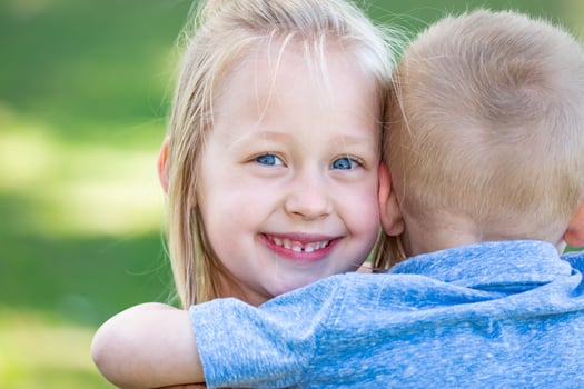 Young Brother and Sister Hugging At The Park photo