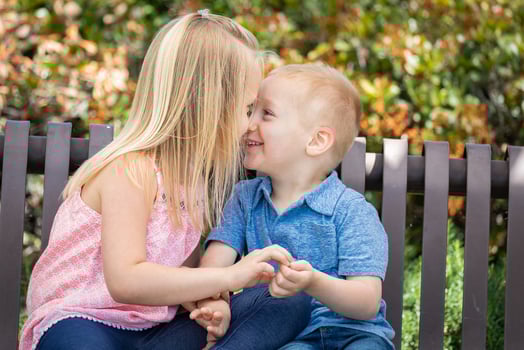 Young Sister and Brother Having Fun On The Bench At The Park photo