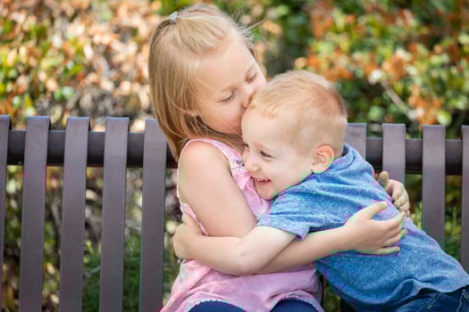 Young Sister and Brother Having Fun On The Bench At The Park photo