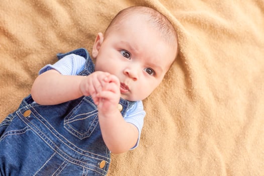 Happy Mixed Race Baby Boy Laying on Blanket photo