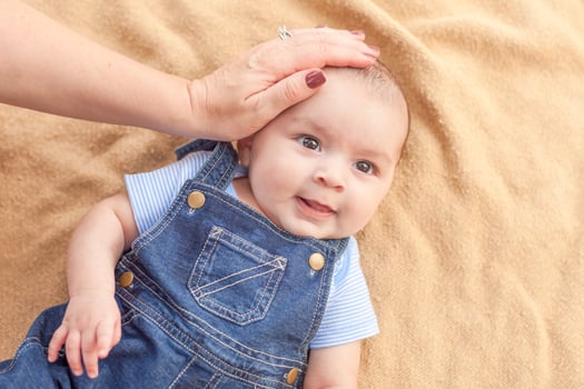 Happy Mixed Race Baby Boy Laying on Blanket photo