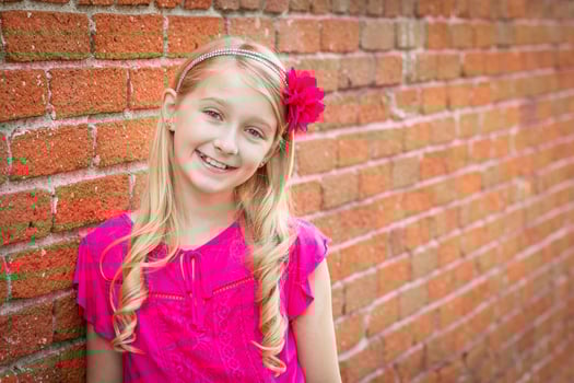 Cute Young Caucasian Girl Portrait Against A Brick Wall photo
