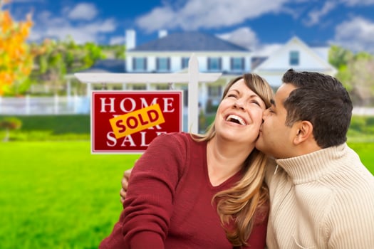 Mixed Race Couple in Front of Sold Real Estate Sign photo