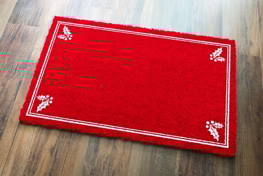 Blank Holiday Red Welcome Mat With Holly Corners On Wood Floor Background photo
