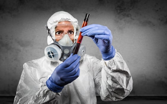 Woman In Hazmat Suit and Gas Mask Holding Test Tube of Blood photo