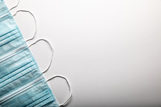 Several Medical Face Masks Pattern Resting on Gradated Surface photo